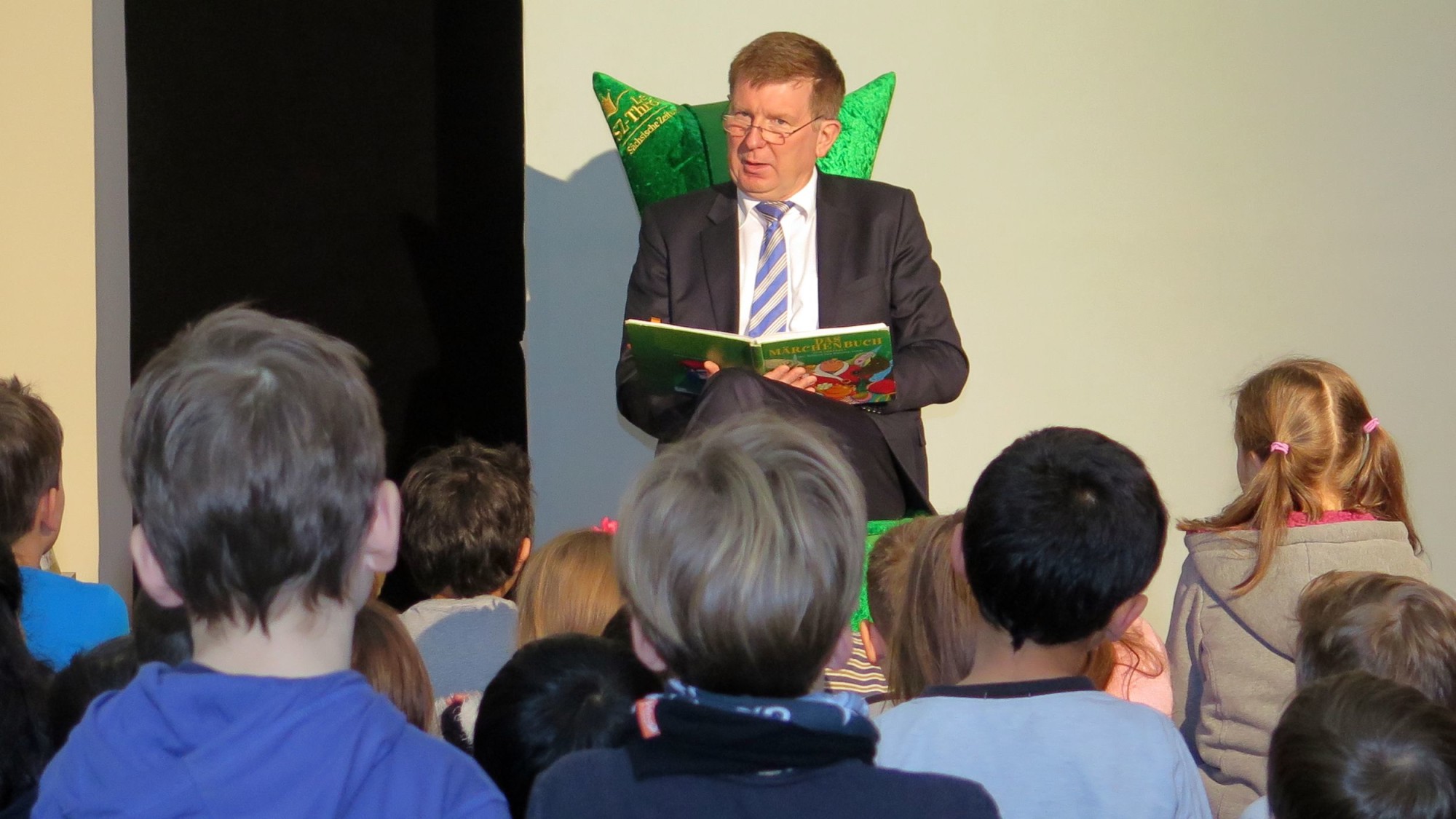 Staatssekretär Frank Pfeil liest Flüchtlingskindern vor.