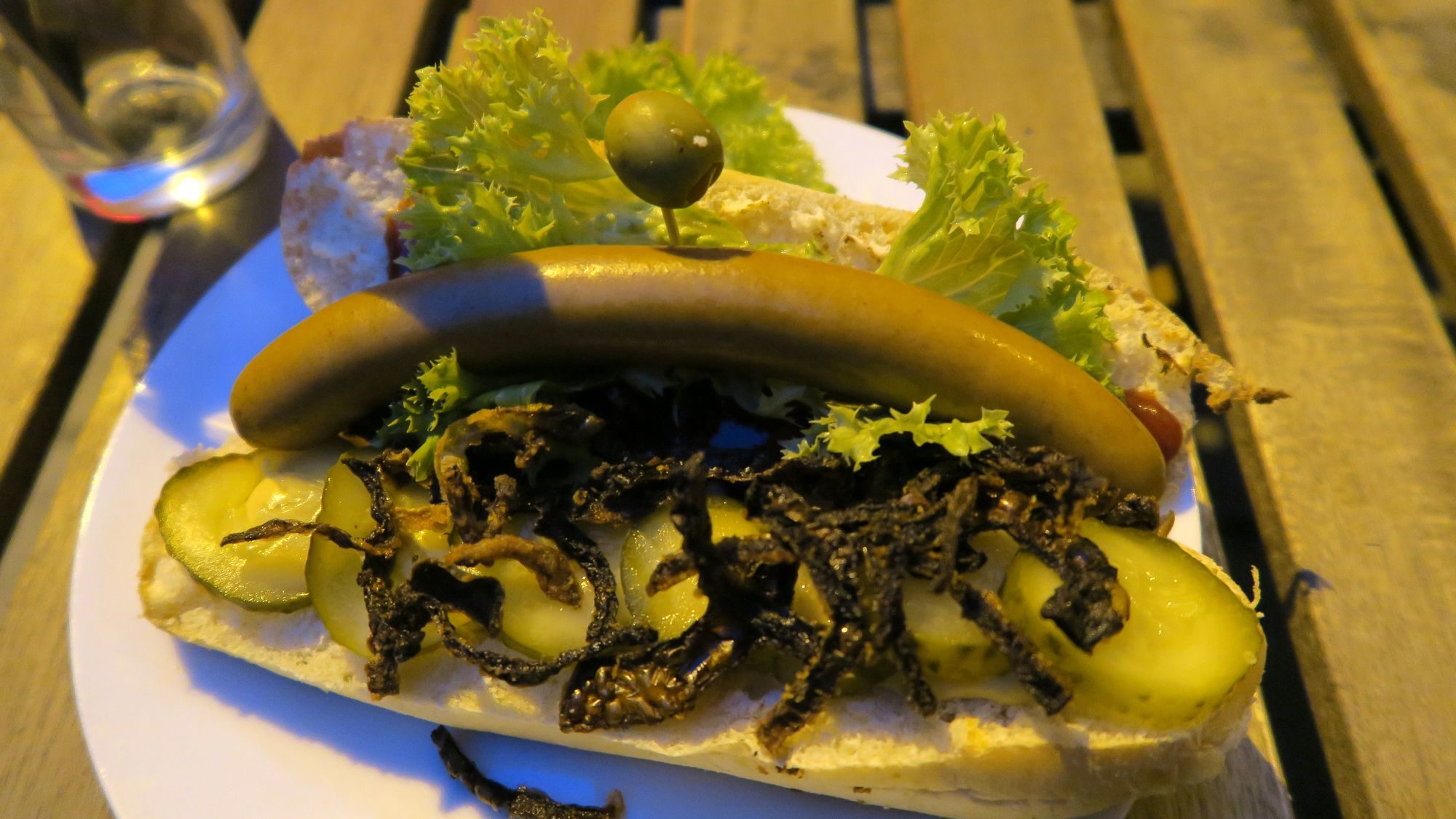 Hot-Dog mit Schweinswurst und Olive