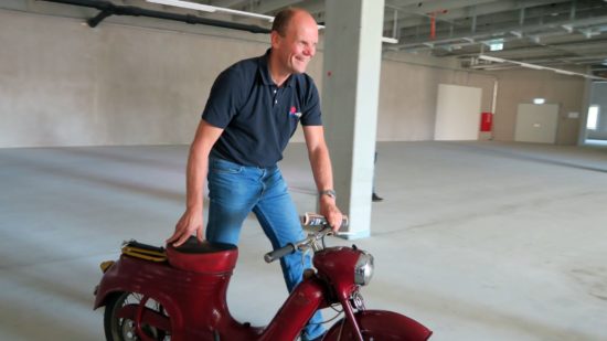 Das erste Exponat ist schon da. Peter Simmel hat sichtlich Spaß mit dem Moped.