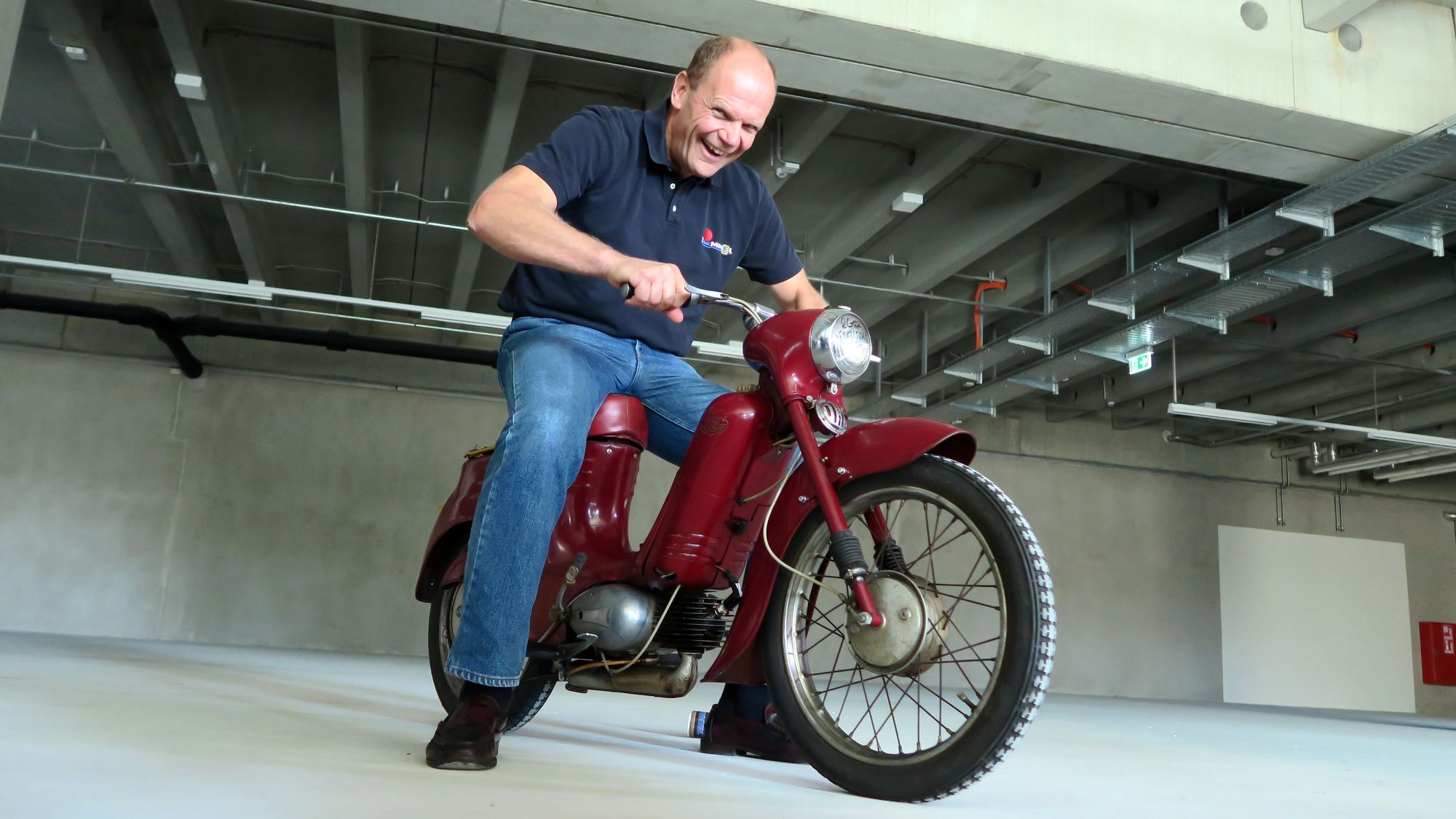 Das erste Exponat ist schon da. Peter Simmel hat sichtlich Spaß mit dem Moped.