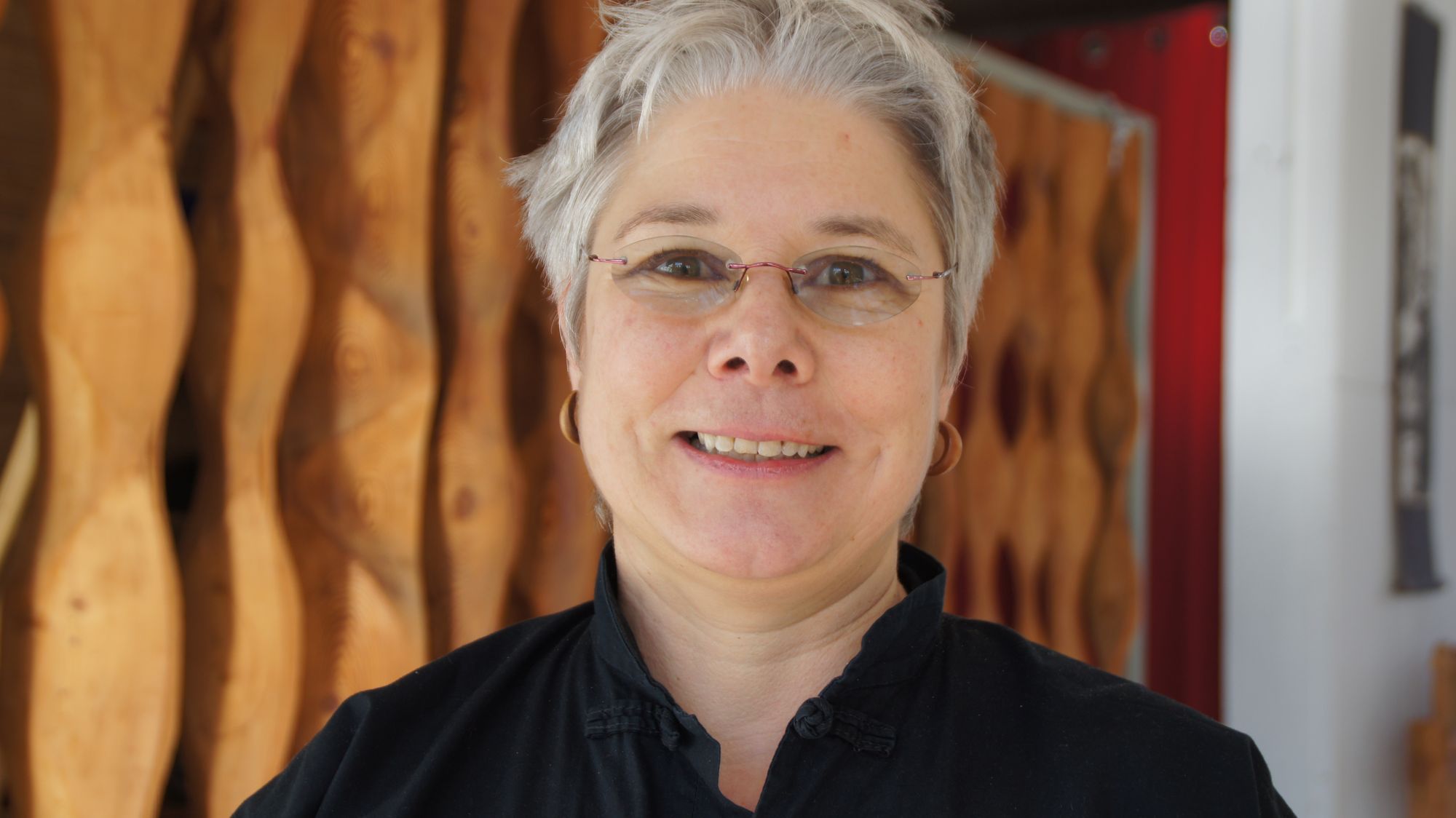 Evelyne Henze vor der dekorativen Holzwand der ehemaligen DDR-Kantine. Als hätte der Raum schon immer von Tai Chi geträumt