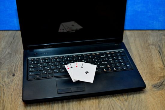 Vier Karten liegen auf der Tastatur eines Laptops.