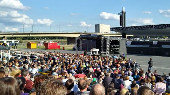 Anna Mateur auf kleiner Bühne vor großer Kulisse im Sommer am Elbufer