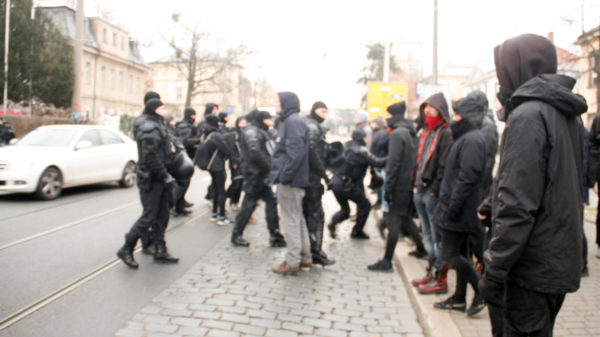 Die Polizei schuppt die Portestierenden zurück auf den Gehweg.