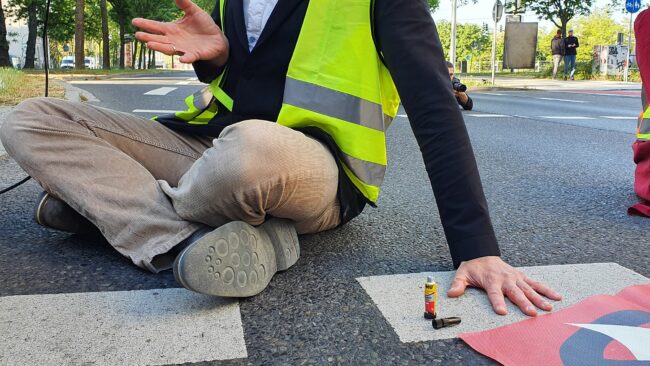 Zwei Aktivisten klebten sich mittels Sekundenkleber an der Straße fest.