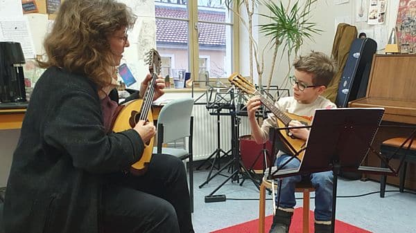 Birgit Pfarr bringt dem 8-jährigen Arthur das Mandolinen-Spiel bei.