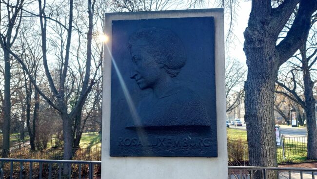 Das Denkmal für Rosa Luxemburg wurde mit der Umbenennung des Platzes gesetzt. Direkt daneben steht etwas verkürzt ihr wohl bekanntestes Zitat: Freiheit ist immer Freiheit der Andersdenkenden.