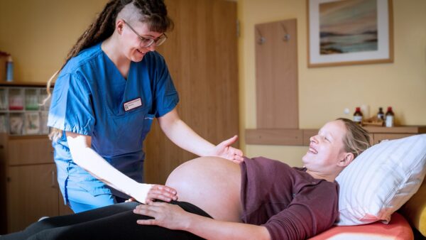 Eine Hebamme tastet einer Schwangeren den Bauch ab. Foto: Diako Dresden