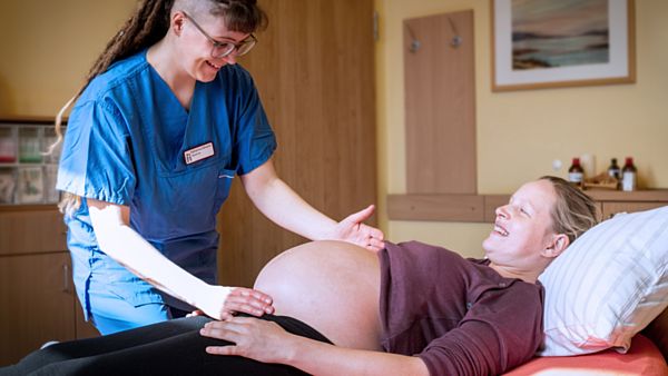 Eine Hebamme tastet einer Schwangeren den Bauch ab. Foto: Diako Dresden