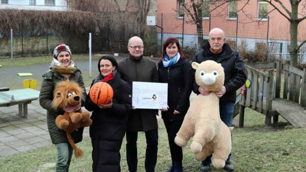 Kinderhausleiterin Silke Dietrich, Barbara Oehlke (Hauptsache Hauptstraße), Christoph Möllers (Barockviertel), Mandy Pretzsch (Stadtbezirksamt) und Andreas Sohr (Spielplatz Kühnert) bei der Übergabe des Spendenschecks.