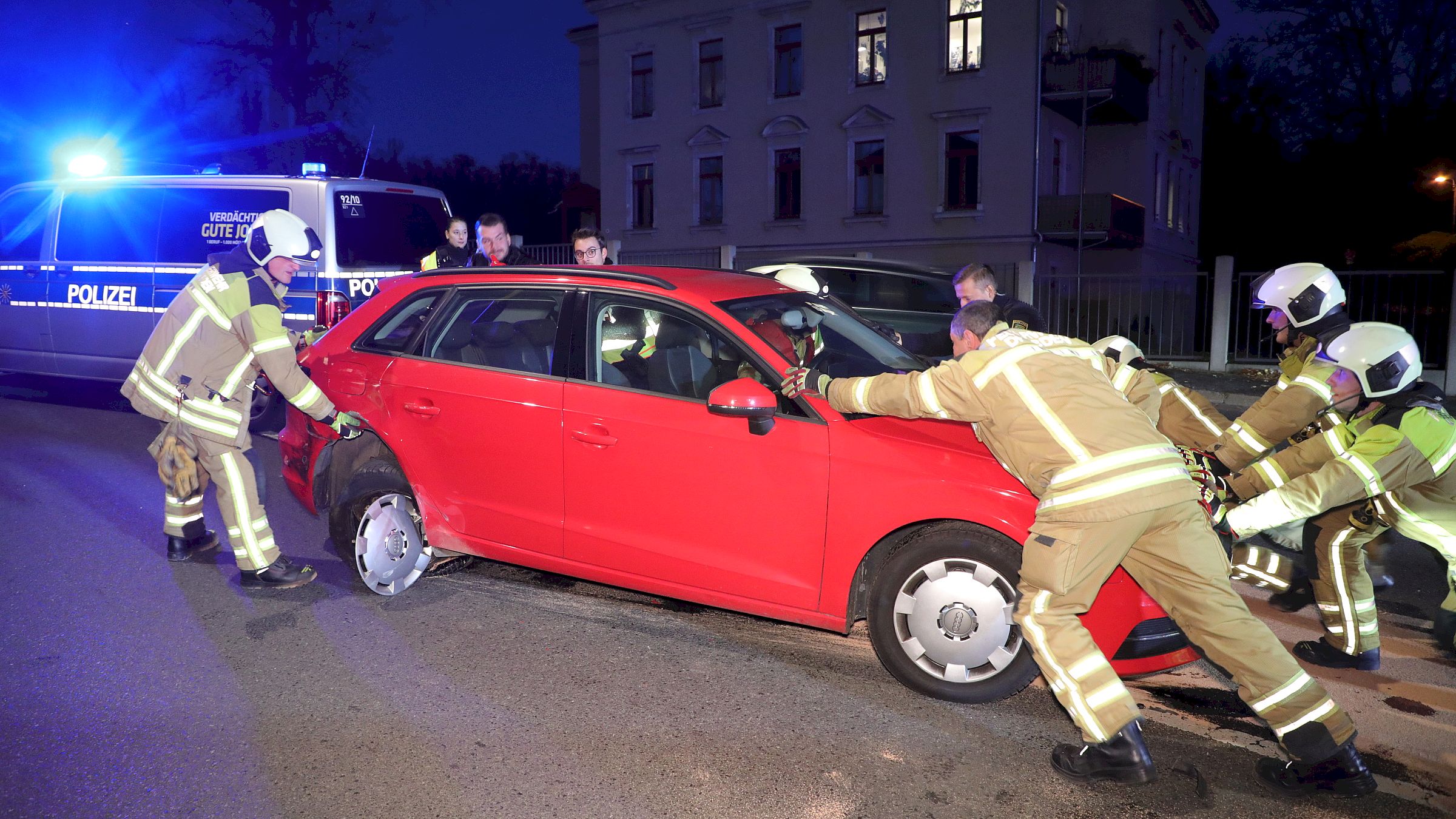 Die Feuerwehrleute schieben einen der beschädigten Wagen von der Straße - Foto: R. Halkasch