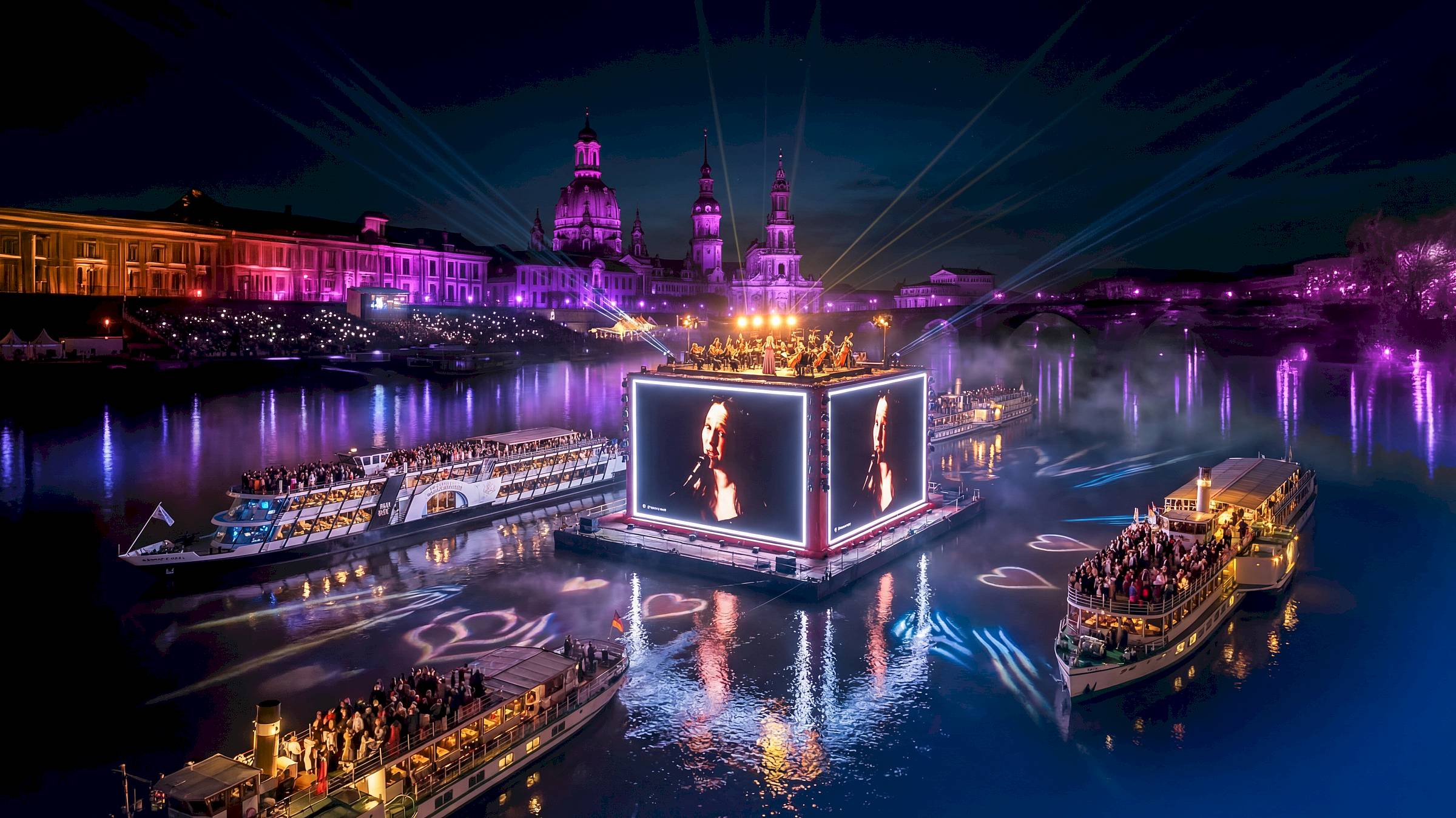 Die Weiße Flotte Sachsen plant ihr Jubiläumsfest unter dem Namen „Elbzauber“. Vorgestellt wird eine Veranstaltung mit Lichteffekten sowie Musik vom Ponton und vom Gelände der Filmnächte. Ein Bild zur Veranstaltung wurde vom Veranstalter mit Künstlicher Intelligenz erstellt.