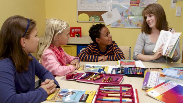 Lehrerin mit drei Grundschulkindern - Foto: Studienkreis