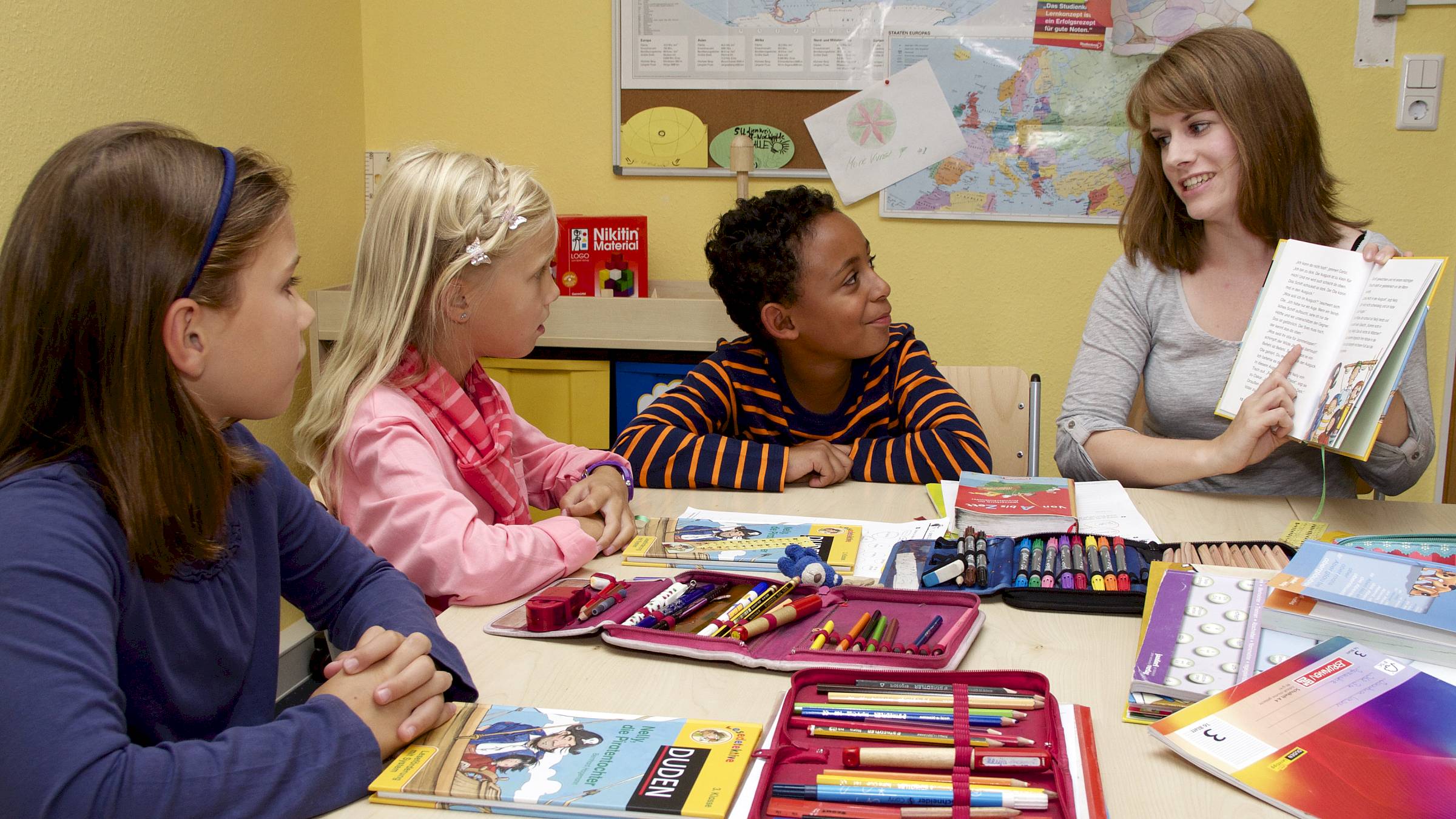 Lehrerin mit drei Grundschulkindern - Foto: Studienkreis