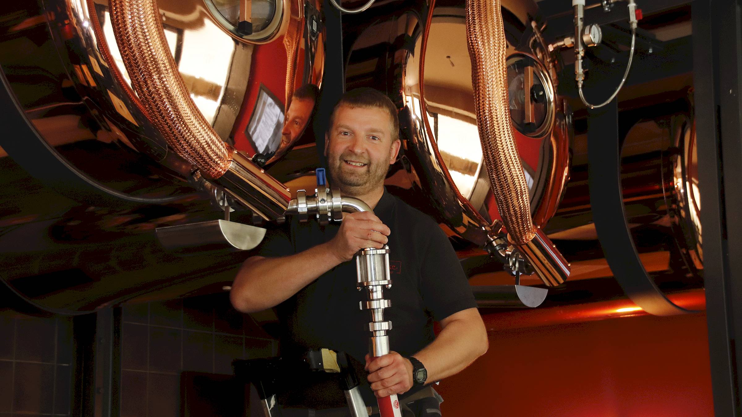 Braumeister Jens Berndt wuchtet den schweren Schlauch an den Tank. Dann muss er nur noch den Hebel umlegen und tausend Liter laufen vom Laster in den Biertank. Foto: Anton Launer