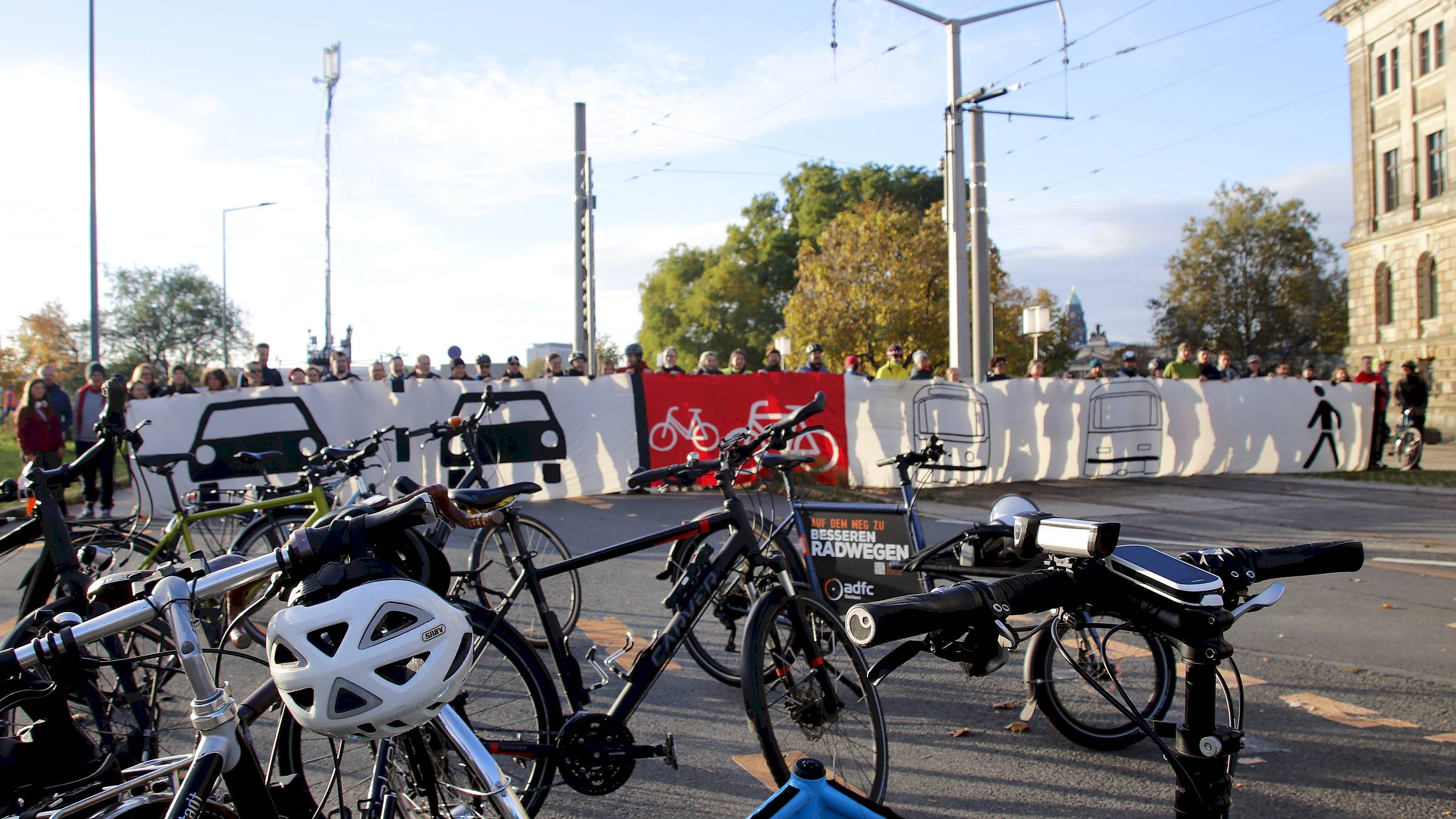 Morgendlicher Protest von Radfahrer*innen am Carolaplatz. Mit dem Banner will der ADFC symbolisieren, wie er sich die stadtwärtige Fahrbahn der Carolabrücke wünscht. Foto: Anton Launer